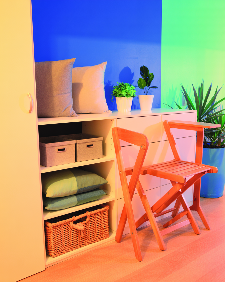 Folded balcony furniture stored neatly in apartment closet with cushions.