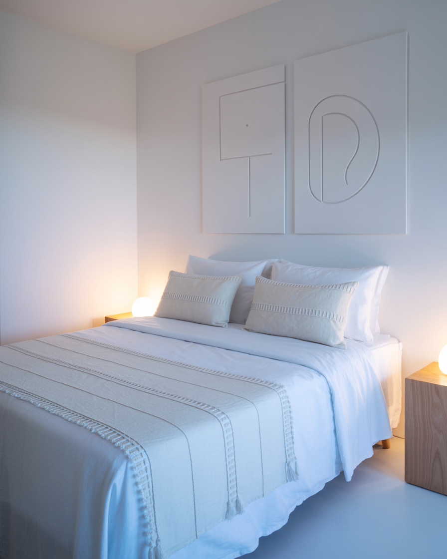 A minimalist blue boho bedroom with geometric patterns, soft blue walls, and simple wooden furniture.