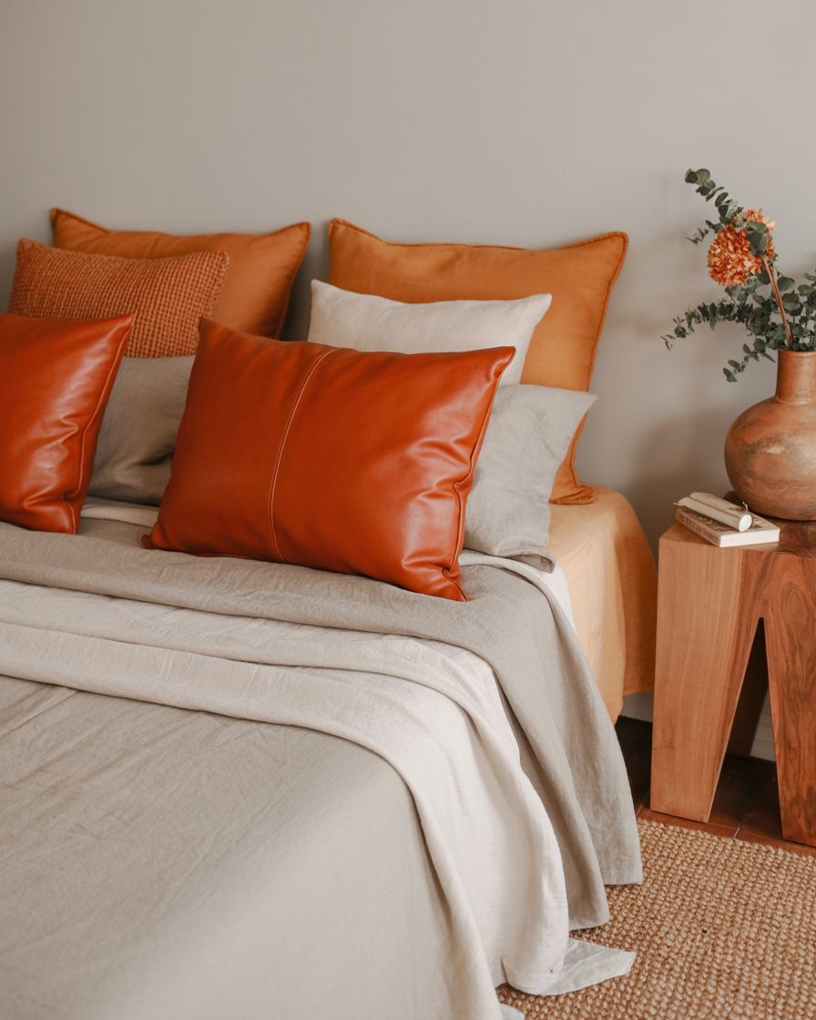 A boho bedroom with rustic orange accents and natural materials.