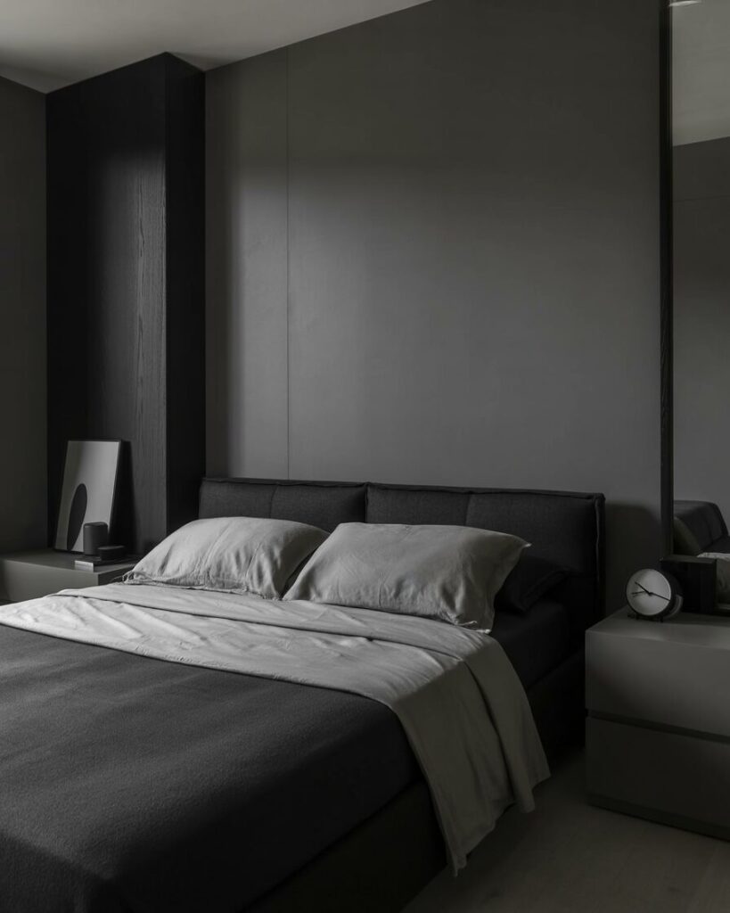 A sleek black and gray bedroom with a minimalist design and soft gray accents.
