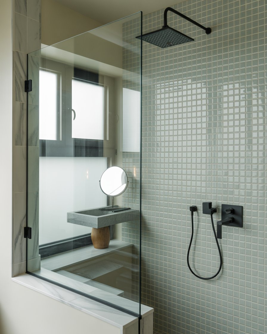 Bathroom with glass shower enclosure and tiled walls.