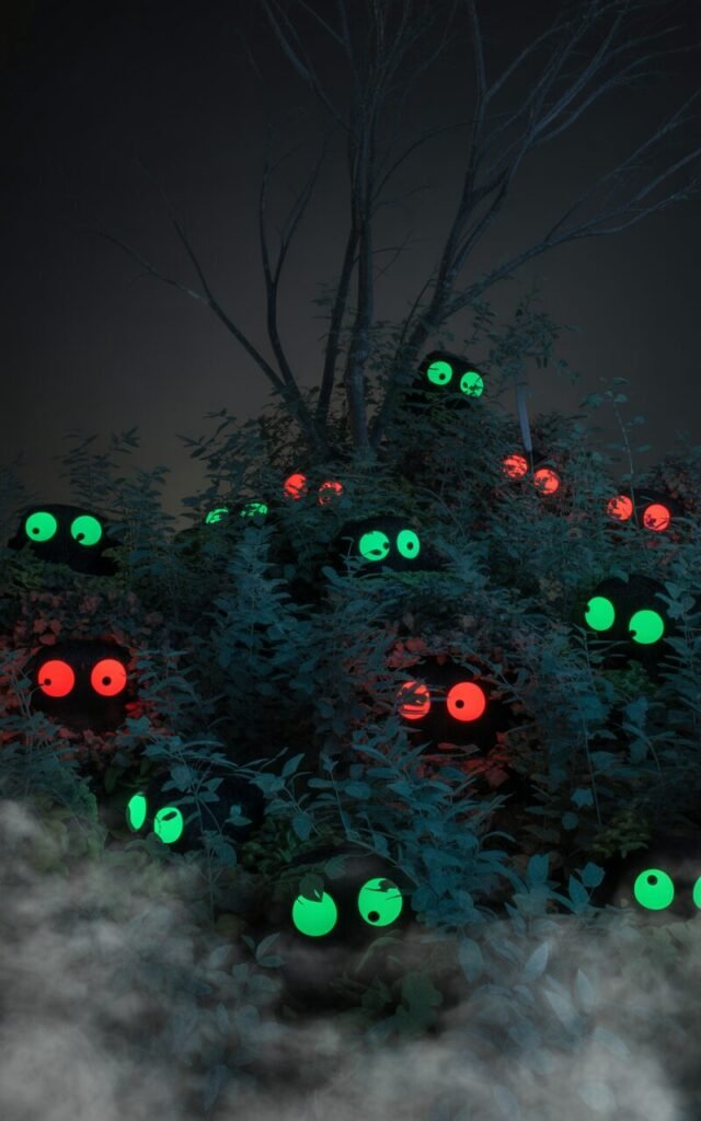 Glowing monster eyes hidden in bushes for Halloween garden decoration.